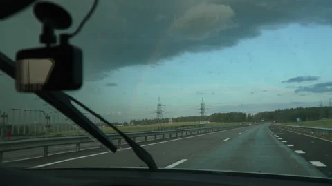 Car with windshield wipers running drives out of rain front towards rainbow. Stock Footage 253183253