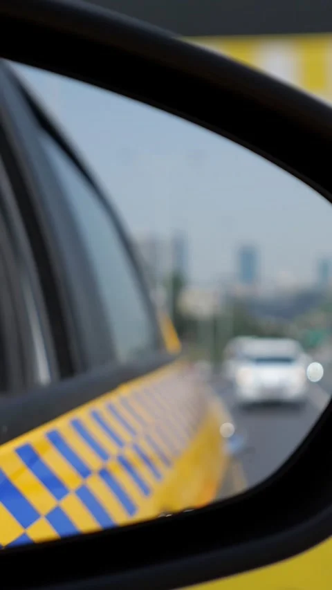 Car wing mirror reflecting a yellow taxi driving on the highway Stock-Footage 341444624