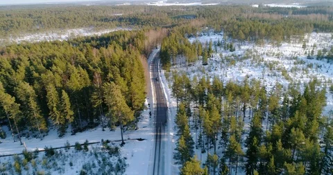 Car on a winter forest road, C4k aerial, tilt down, drone shot, following a v Stock Footage 113722571