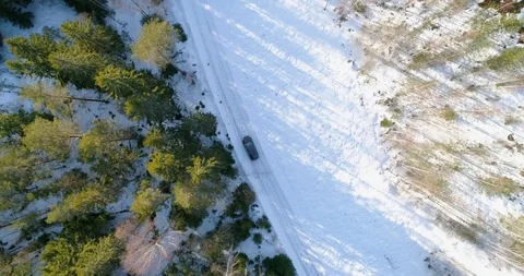 Car on a winter forest road, C4k aerial, top down, drone shot, following a ve Stock Footage 113723985