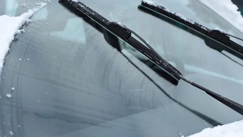 Car wiper blades clean windshield from snow in winter Stockbeeldmateriaal 123402438