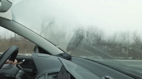 Car wipers on, raindrops run down windshield of car, male hands holding helm 스톡 동영상 148447785