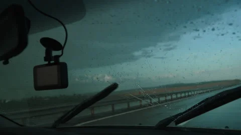 Car wipers remove raindrops from windshield during sudden rain on highway. Stock Footage 253555822