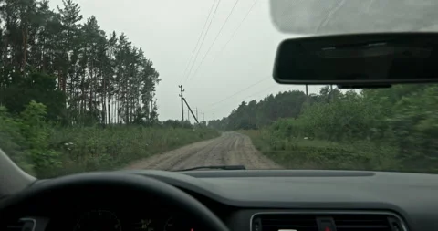 Car wipers sweeping rain from windshield while driving on dirt road Stock Footage 340829318