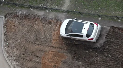 Car wrong parked and left on lawn while machinery makes urban land improvement Stock Footage 49400370