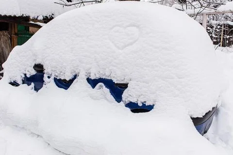 A Car in the yard with a large snowdrift Stock Photos