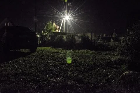 A car in the yard at night with a light from the headlights Stock Photos
