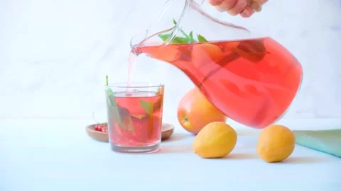 Carafe of fruit compote. A woman's hand pours compote into a glass. Stock Footage 279972541