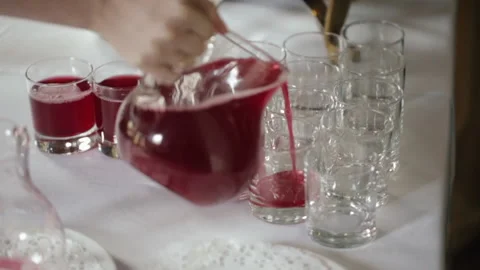 Carafe Pouring red soft drink into a glass against table background, close-up Stock Footage 219610592