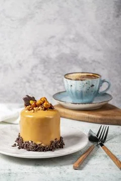 Caramel cake on a gray background. Chocolate and hazelnut cake with a cup of  Stock Photos