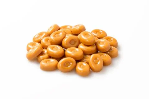 Caramel candies stack over white background. closeup of circle shape candy gr Stock Photos