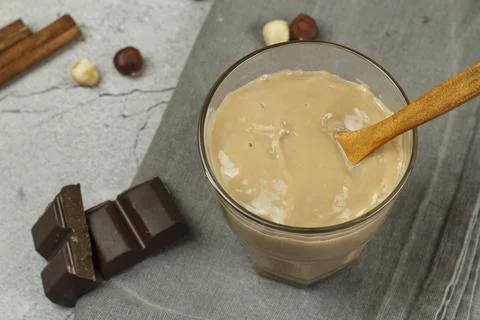 Caramel chocolate pudding on a gray table with chocolate and nuts. Stock Photos