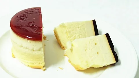 Caramel custard pudding cake cut into half and slices on a white plate. Stock Footage 345339599