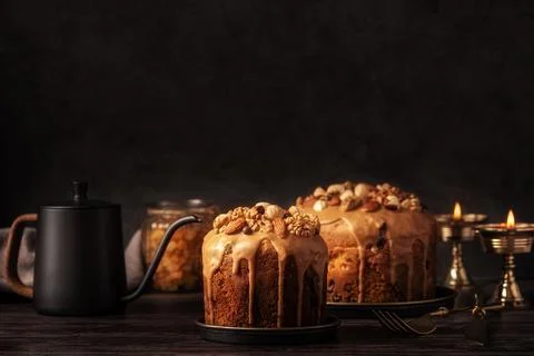 Caramel glazed Easter cakes decorated with nuts on dark background. Stock Photos