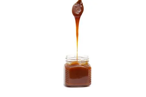 Caramel in a jar on a white background Stock Photos