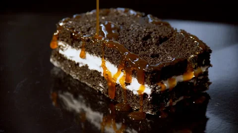 Caramel / maple syrup poured on a slice of chocolate pastry Stock-Footage 169839255