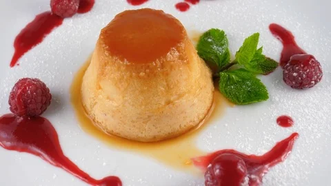Caramel pudding with caramel sauce and raspberries Stock Footage 79986994