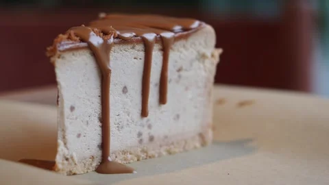 Caramel Sauce Drizzling Over a Slice of Cheesecake Stock Footage 337878839