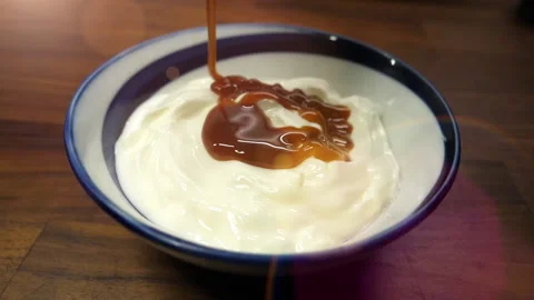 Caramel sauce flows in slow motion over cream cheese Stock Footage 171369554