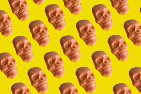 Caramel shaped human skull pattern on vibrant yellow background Stock Photos