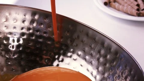 Caramel thick cream pours a thin stream into a metallic deep bowl. Stock Footage 79245936