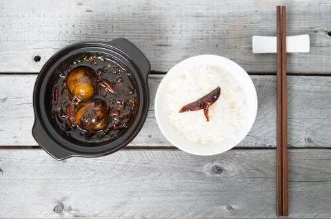 Caramelized balut - boiled developing duck embryo in a clay pot and a bowl of 스톡 사진