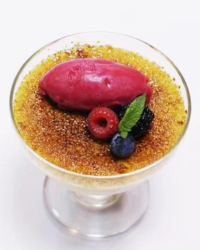 Caramelized vanilla creme brulee with raspberry sorbet and mix berries Stock Photos