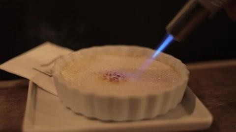 Caramelizing Creme Brulee with a Torch Stock Footage 129333702