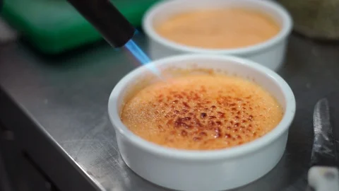 Caramelizing sugar on creme brulee Stock Footage 95287894