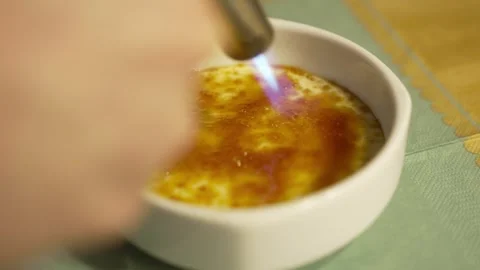 Caramelizing the sugar on crème brûlée with a kitchen torch Vídeos de archivo 295777406
