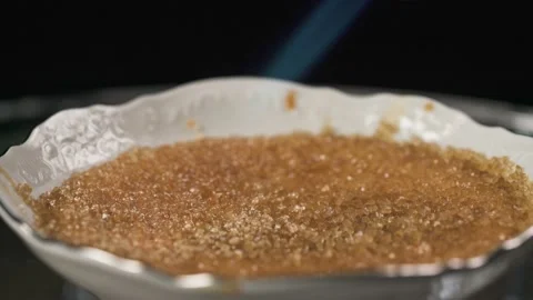 Caramelizing sugar on the top of creme brulee dessert using gas torch Stock Footage 150435607
