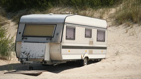 Caravan camper van on Beach. Forbidden old Vintage parked trailer on Sand. Stock-Footage 129384410