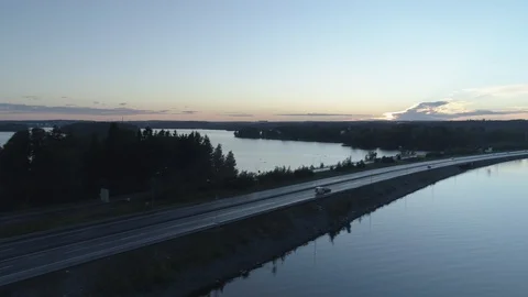 Caravan Drives Across Bridge on a Tranquil Lake Video stock 85976259