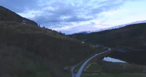 Caravan Going Through Mountain Road At Sunset Near A Lake Stockbeeldmateriaal 84688613
