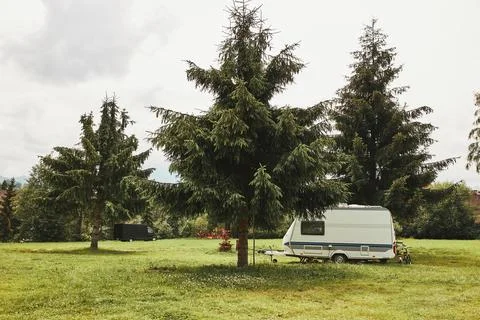 Caravan left among the pine trees on campsite Stock Photos