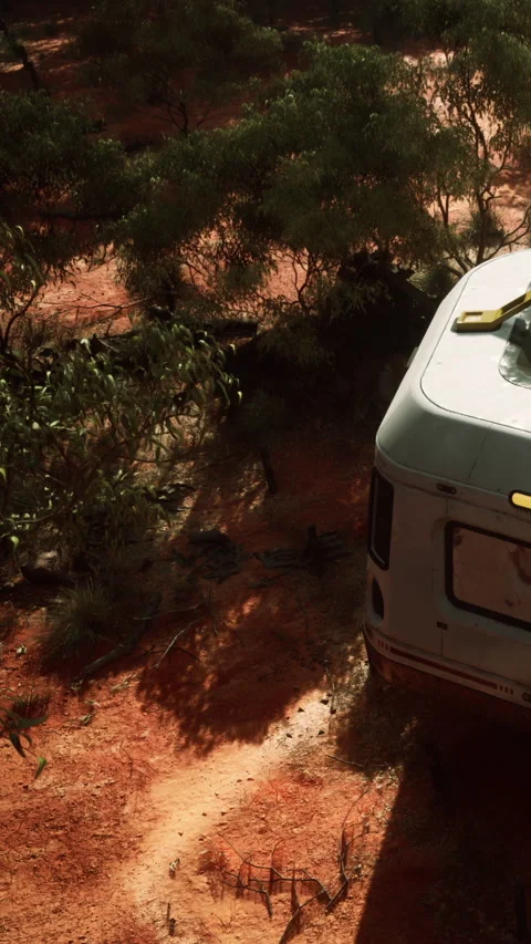 Caravan parked on red dirt with plants surrounding in remote area Stock Footage 343169891