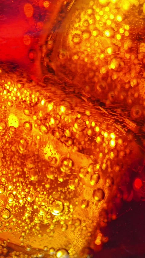 Carbonated beverage with golden bubbles and orange liquid texture in closeup Stock Footage 344992956
