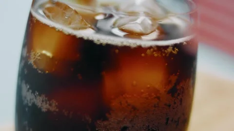 Carbonated cola bubbling around large ice cubes, 4K Stock Footage 341120731