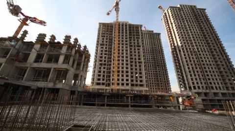 Carcass in between unfinished tall buildings and cranes Stock Footage