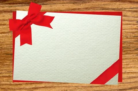 The card decorated with a red bow on envelope over wooden background Stockfoto's