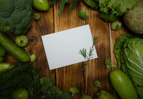 Card message with frame green vegetables on a wood background Stock Photos
