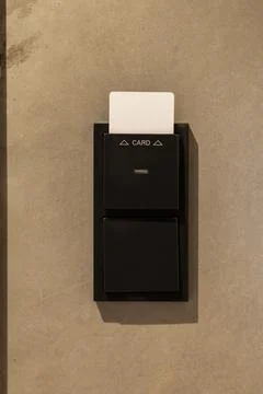 A card reader is mounted on a smooth, light-colored wall, allowing guests to  Stock Photos
