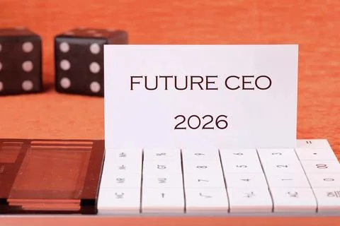 A card stating Future CEO 2026 sits atop a white calculator near two dice, all Stock Photos