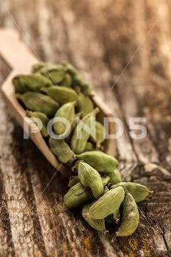Cardamom seasoning in a spoon on wooden table Stock Photos