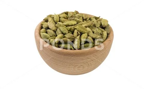 Cardamon seeds in wooden bowl isolated on white background. 45 degree view. S Stock Photos
