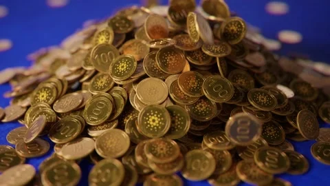 Cardano (ADA) cryptocurrency coins falling into a pile on a textured surface. Stock Footage