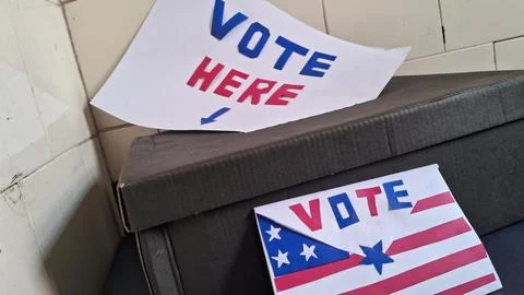 Cardboard ballot box featuring red white and blue vote signs Stock Photos