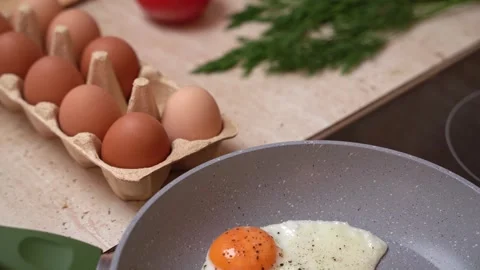 A cardboard box with chicken eggs on the kitchen table, a tomato and fresh herbs Stock Footage 275961437