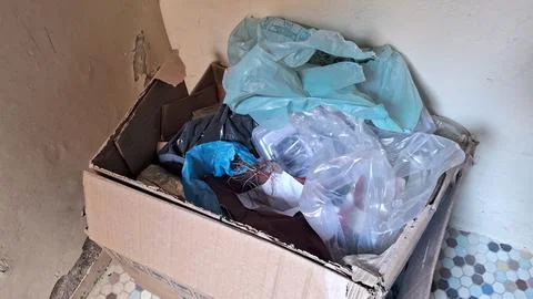 Cardboard box filled with assorted plastic waste and household trash items Stock Photos