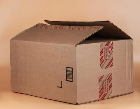 Cardboard box with opened flap for packaging and shipping items indoors Stock Photos